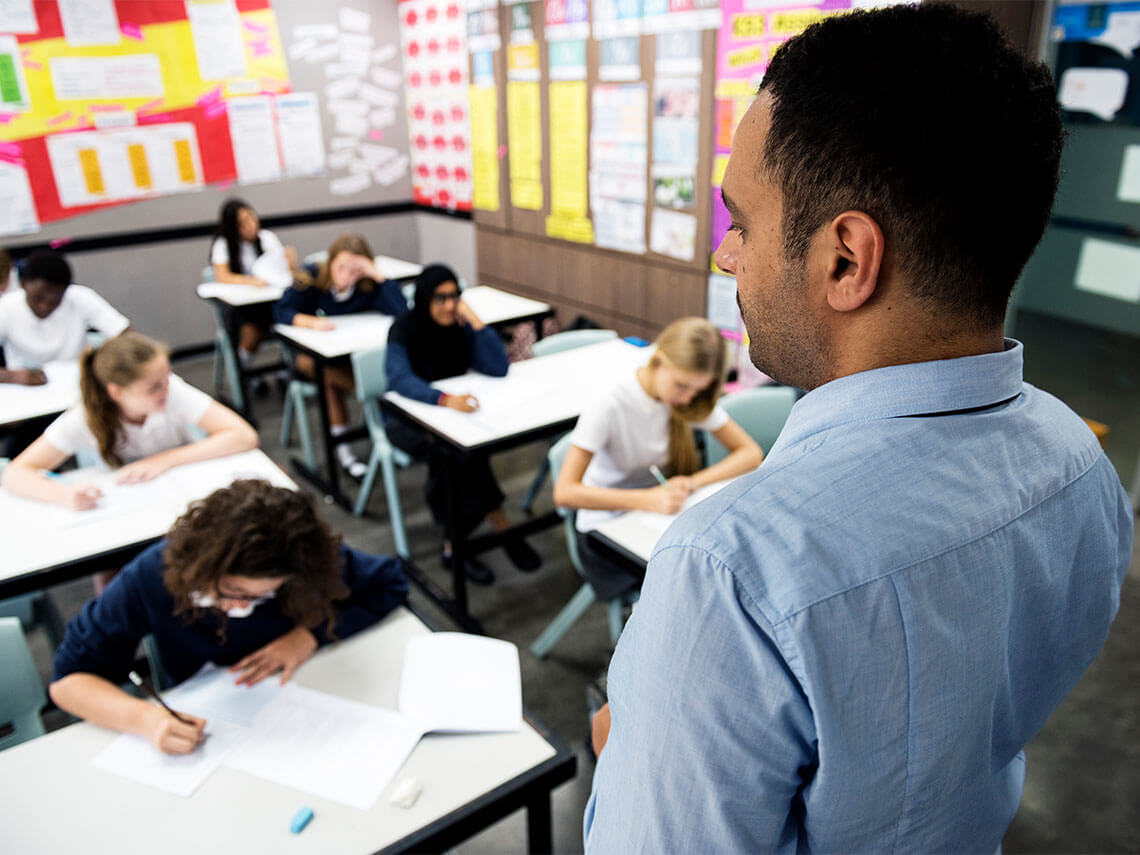 Teacher standing in from of classroom full of students